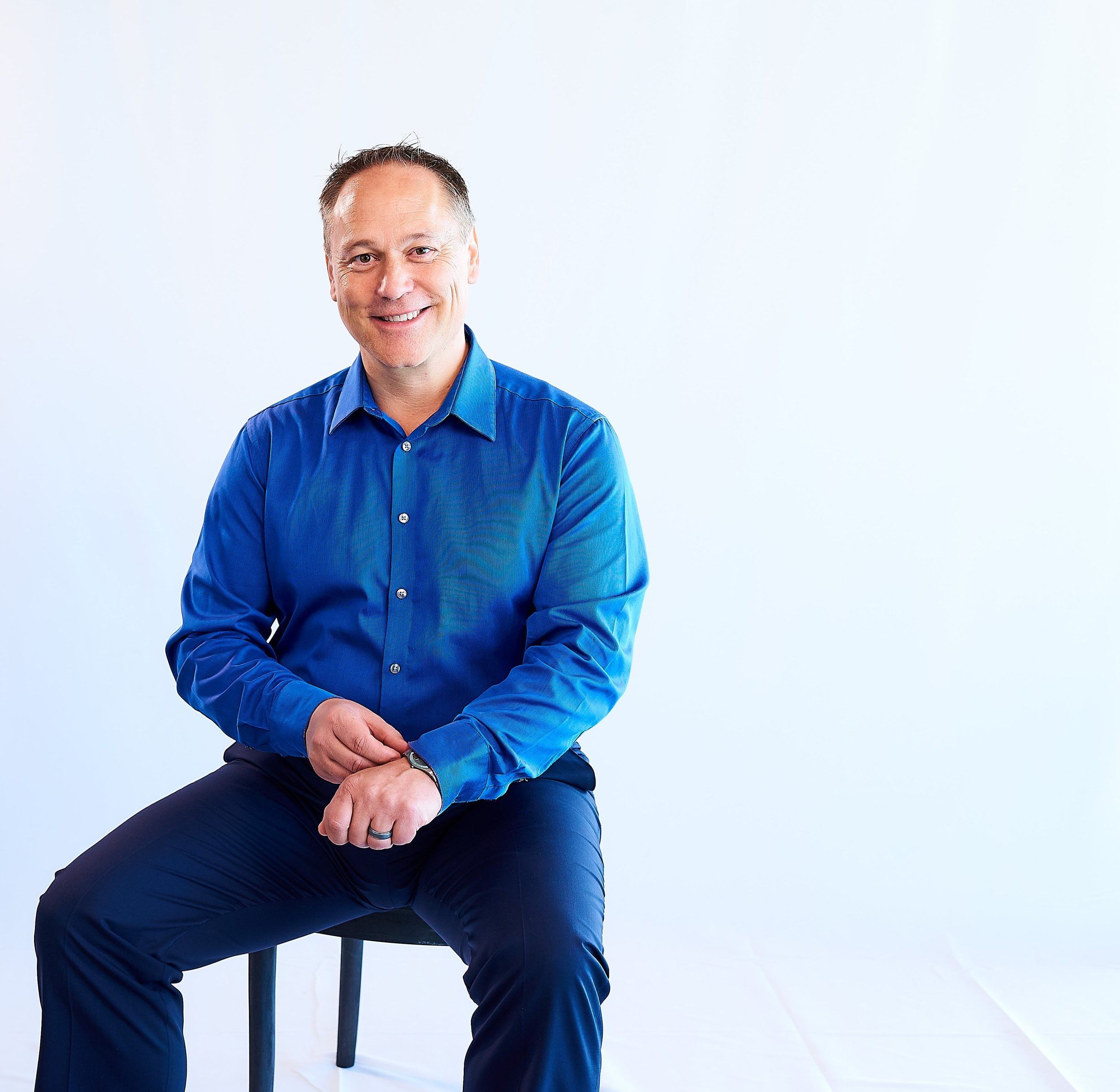 Trevor McGregor seated, in a blue shirt